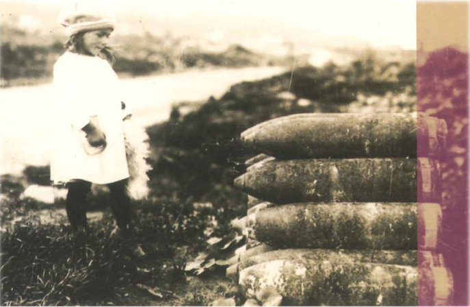 Fillette fixant une pile d’obus d’artillerie lourde, vers 1920, Chavignon (Aisne). Archives départementales de l’Aisne, cote FRAD002 Fillette fixant une pile d’obus d’artillerie lourde, vers 1920, Chavignon (Aisne). Archives départementales de l’Aisne, cote FRAD002