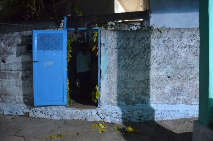 entrebâillement d'une porte bleu, on aperçois un jeune homme