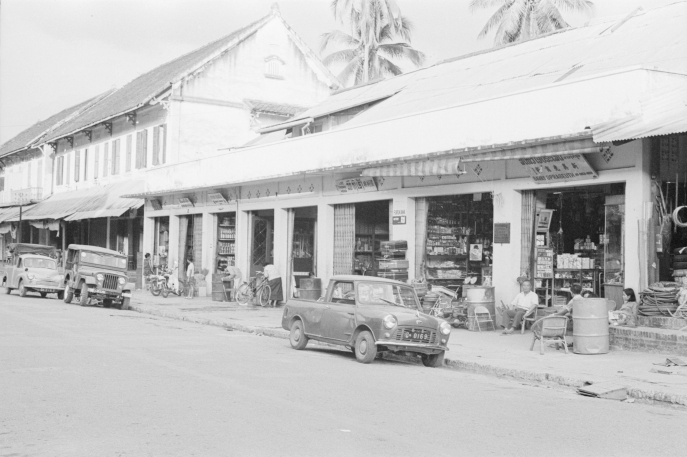 photo en noir et blanc d'une rue commerçante avec des étales