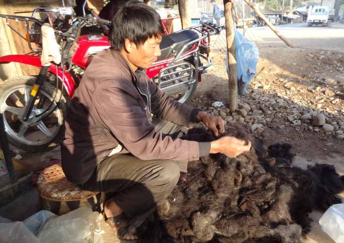 photo en couleur d'un artisan en train de travailler a même le trottoir