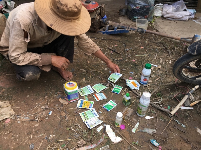 photo d'un agriculteur étalant différents pesticides qu'il utilise