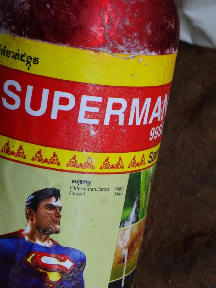 photo de superman sur bouteille de pesticide rouge